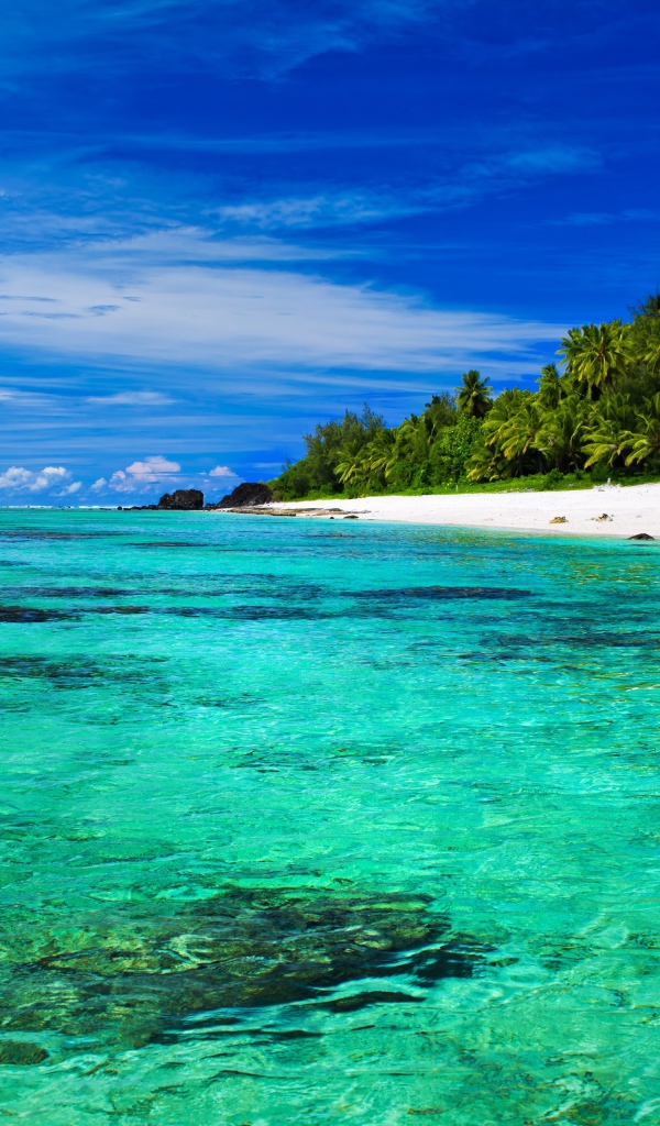 Прозрачная голубая вода в океане у тропического пляжа