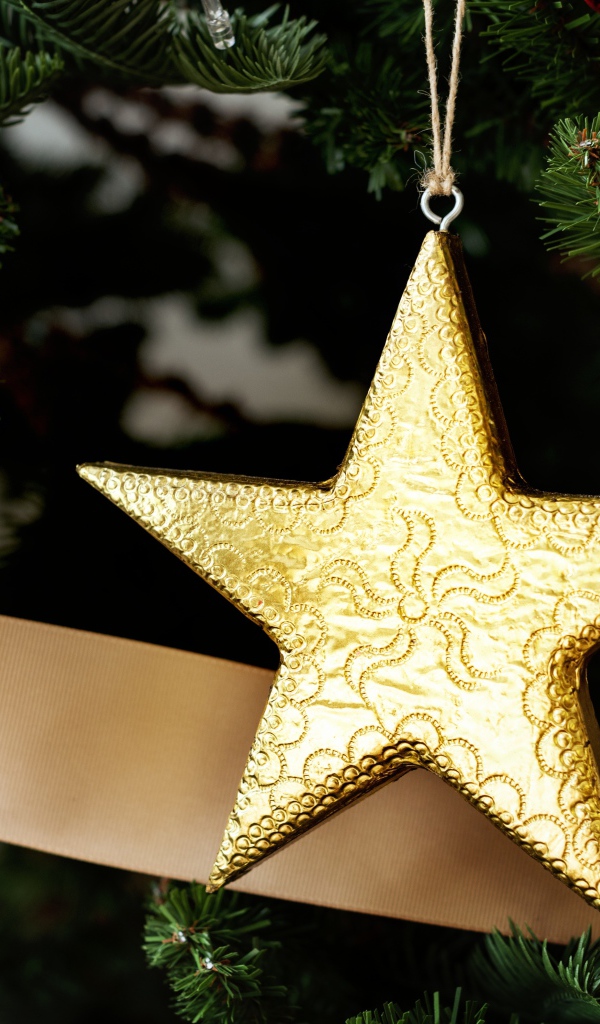 Золотая звезда и шар на новогодней елке