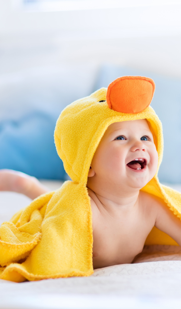 Маленький улыбающийся грудной ребенок в костюме утенка