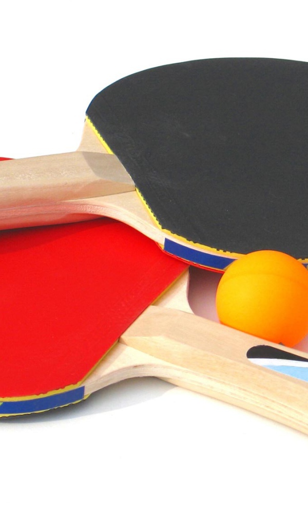 Красная и желтая ракетки и мяч на белом фоне  