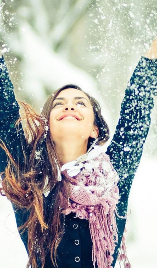 Красивая девушка радуется снегу 