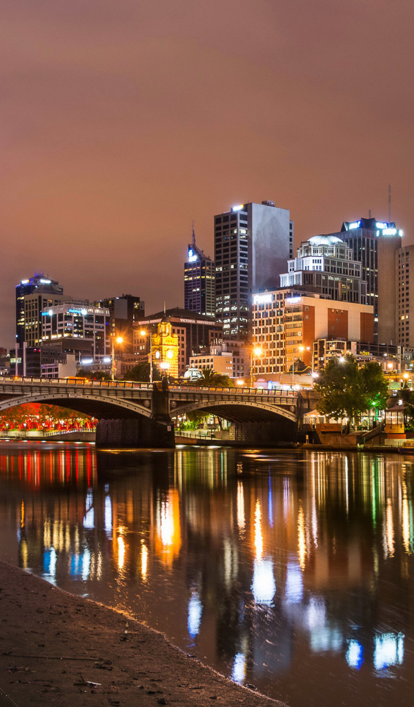 Огни ночных небоскребов города Мельбурн отражаются в водном канале. Австралия