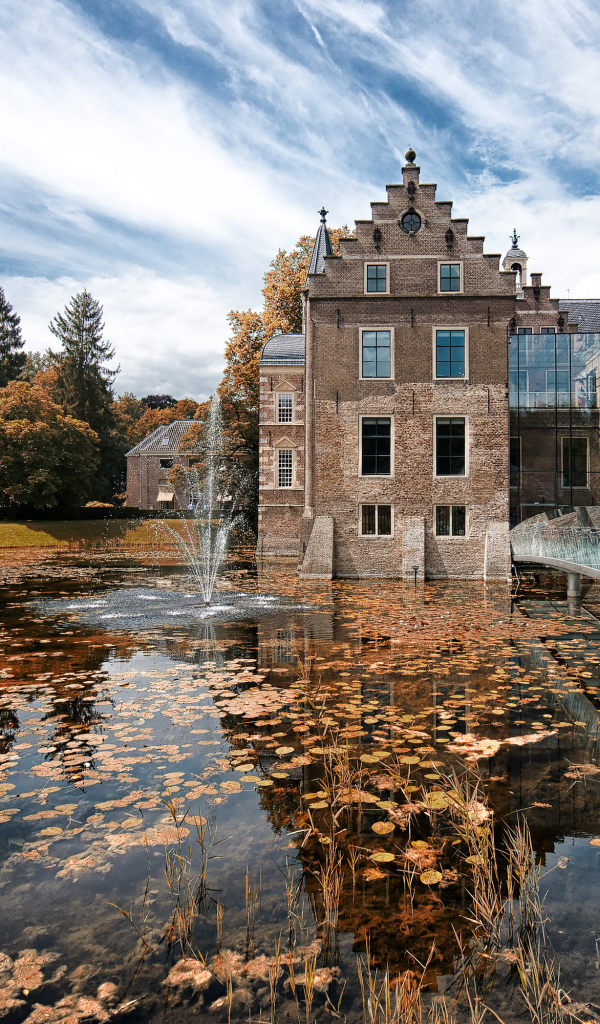 Замок Huis te Ruurlo у воды под красивым небом, Нидерланды