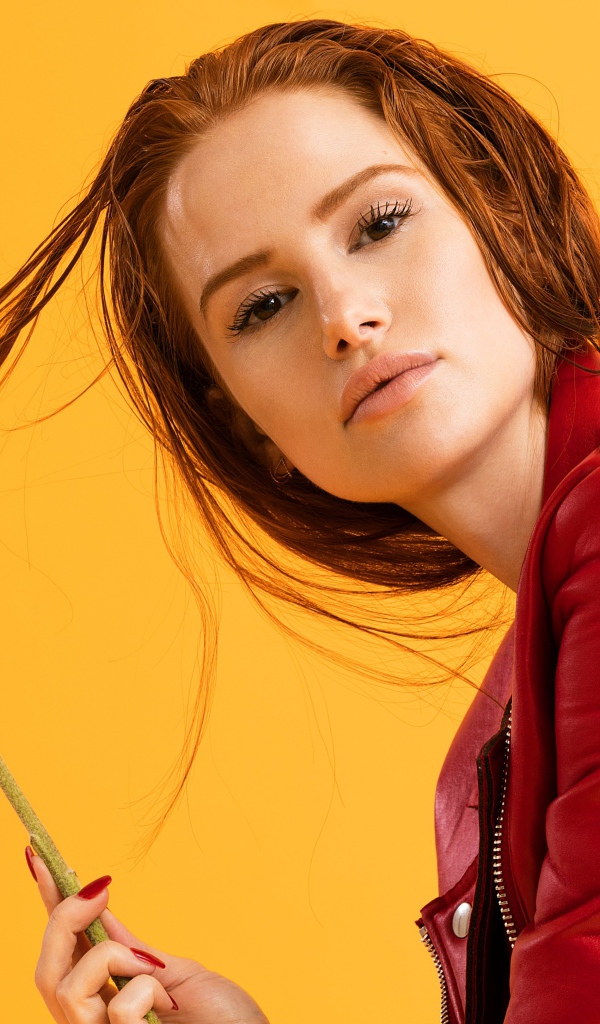 Актриса Мэделин Петш в красной куртке фото на оранжевом фоне