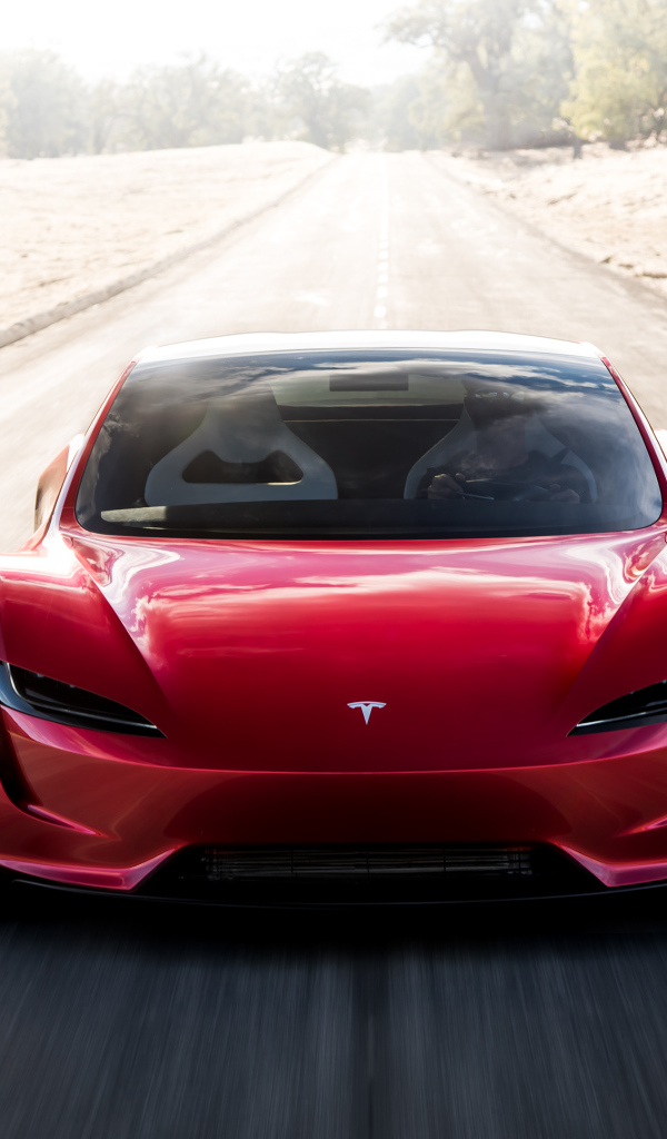 Красный автомобиль Tesla Roadster на трассе, вид спереди