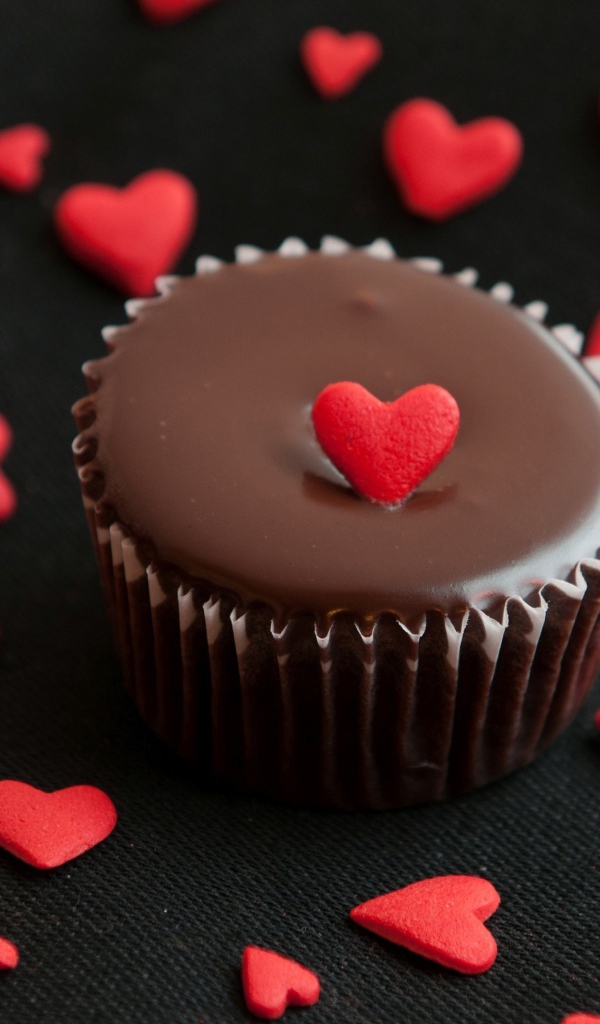 Аппетитный шоколадный кекс украшен маленькими сердечками