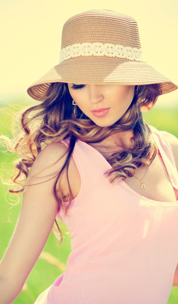 A tender girl in a hat walks the field