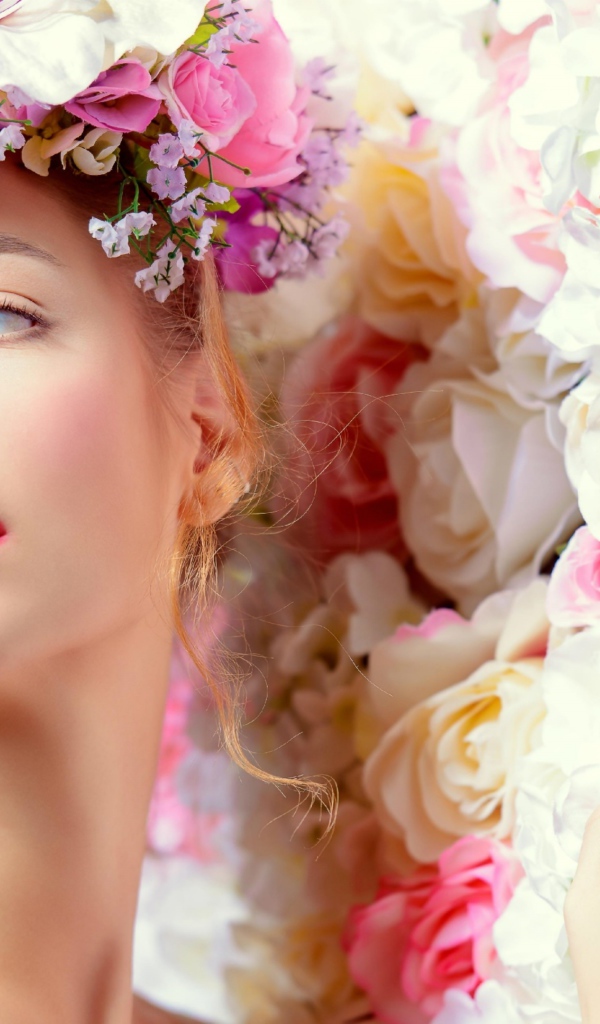 Нежная голубоглазая девушка с венком из цветов на голове