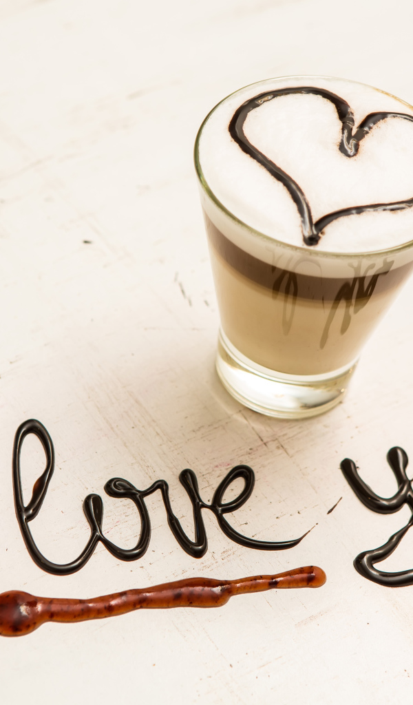 Стакан кофе с сердцем и надпись шоколадом Я тебя люблю  на столе