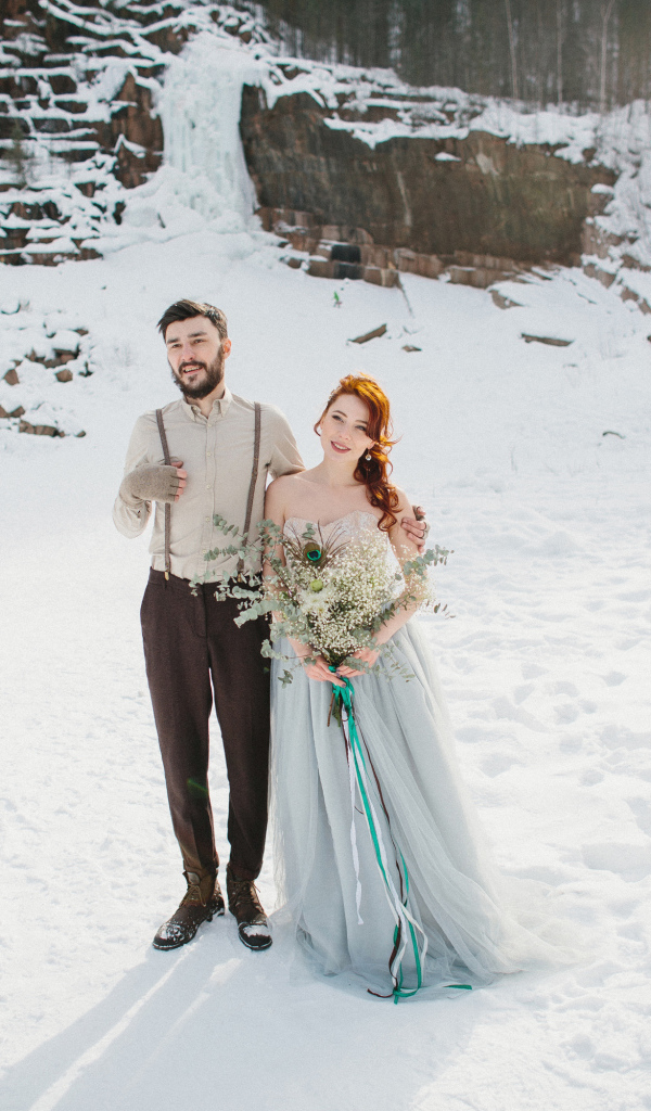 Влюбленная пара молодоженов стоит на снегу