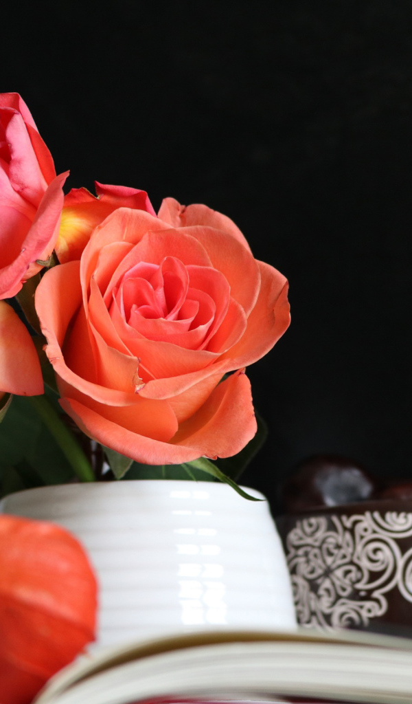 Букет роз в вазе на столе с книгой