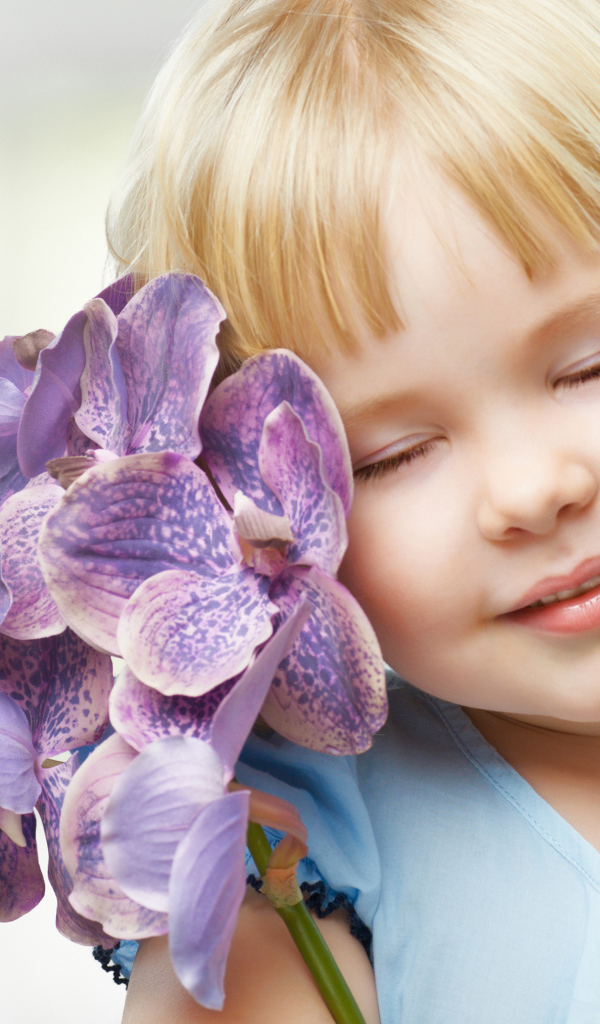 Маленькая девочка блондинка с цветами орхидеи