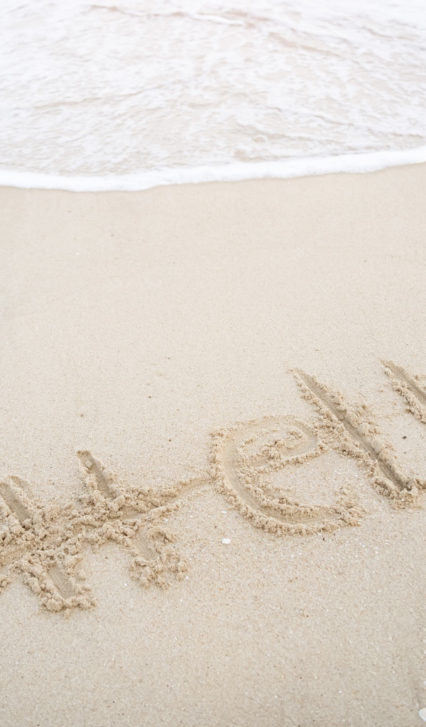 Надпись Hello на мокром песке у моря летом 