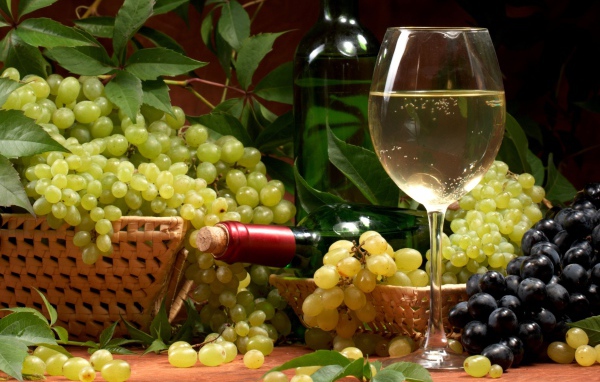 Белое вино и гроздья винограда