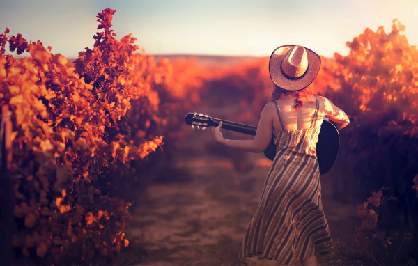 Девушка с гитарой в винограднике