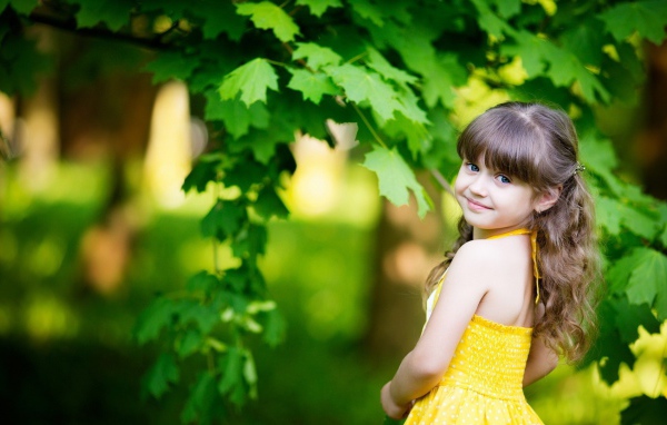 Маленькая девочка у зеленого клена