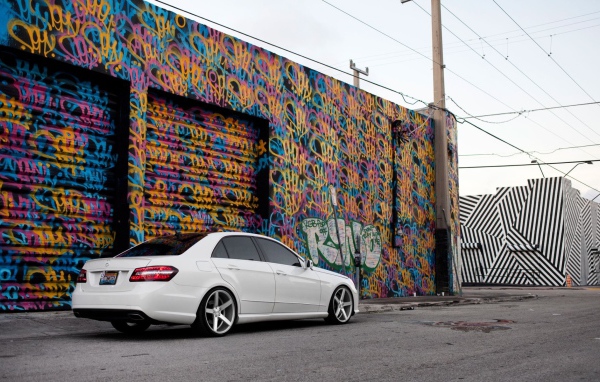 Белый Mercedes-Benz у раскрашенного гаража
