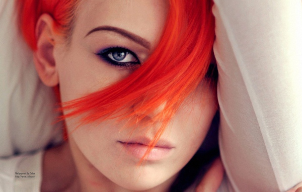 Прядь оранжевых волос на лице у девушки