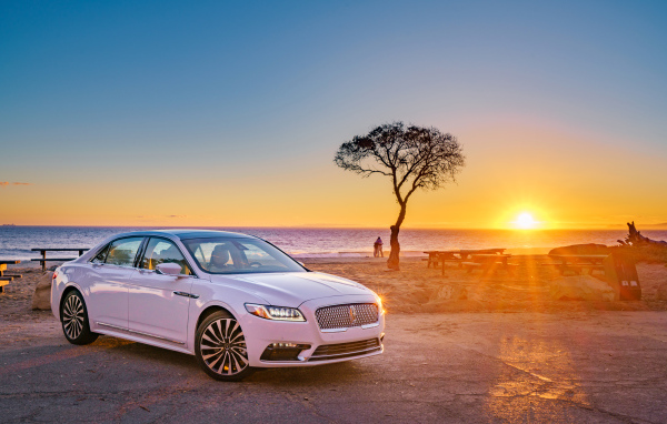 Белый Lincoln Continental 2017  года на фоне заката 