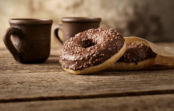 Сладкие круглые пончики с шоколадом на столе 