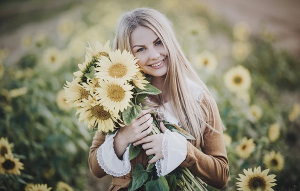 Милая улыбающаяся девушка с букетом цветов подсолнуха