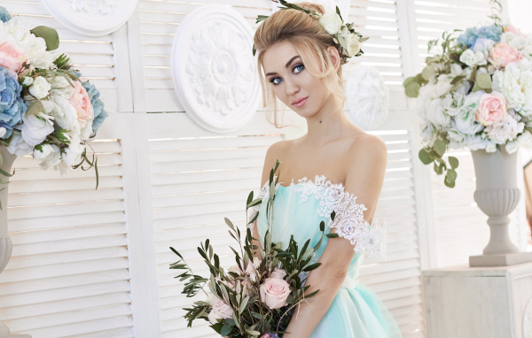 Spectacular look of a blue-eyed blonde in a beautiful dress with a bouquet of flowers