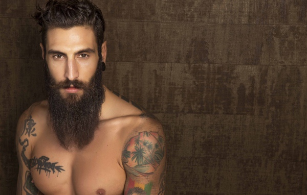 Молодой парень модель Маттео Маринелли с бородой и татуировками на теле