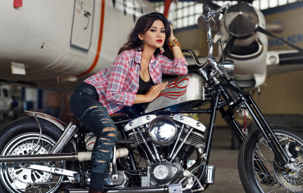 Молодая девушка азиатка в джинсах на мотоцикле
