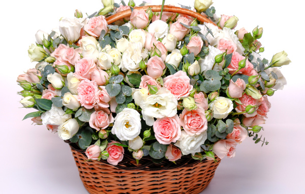 Корзина с красивым букетом цветов роз, эустомы на розовом фоне