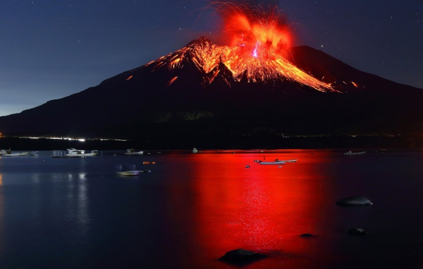 Вулкан Сакурадзима извергается  на фоне воды 