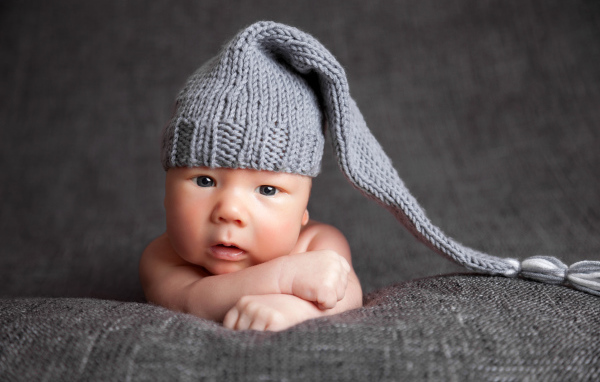 Милый младенец в большой серой вязаной шапке