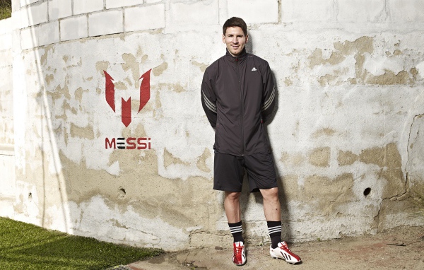 Футболист Лионель Месси позирует  на фоне стены 