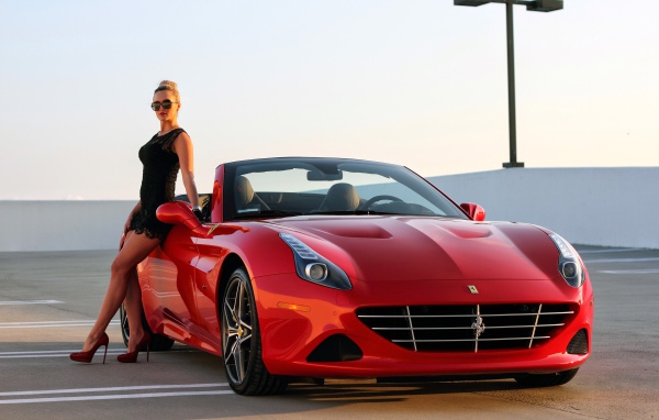 Красивая девушка у красного кабриолета Ferrari California