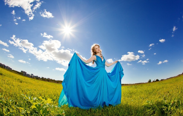 Девушка в красивом голубом платье на фоне неба