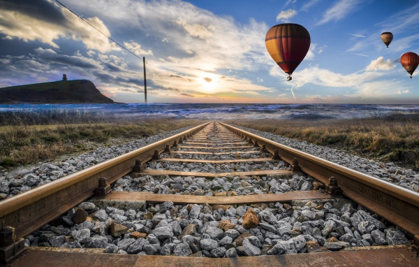 Воздушный шар в красивом голубом небе над железной дорогой