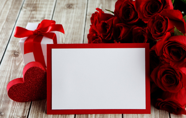 Букет красных роз на столе с подарком и красным сердцем, шаблон поздравительной открытки