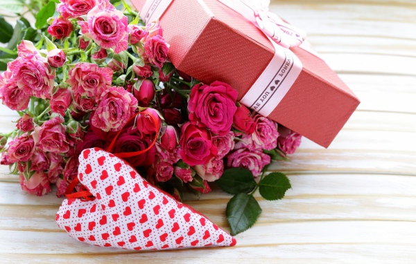 Букет розовых роз с подарком и сердечком на столе