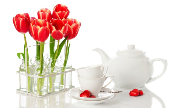 Красные тюльпаны с чайным сервизом на белом фоне