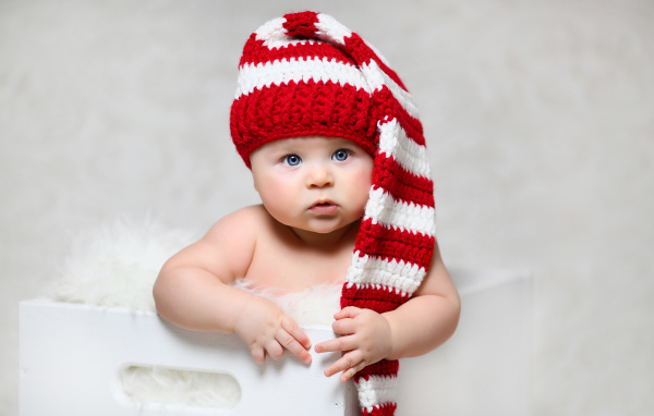 Голубоглазый младенец в длинной вязаной шапке