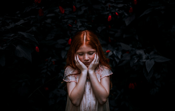 Маленькая рыжеволосая девочка с закрытыми глазами 