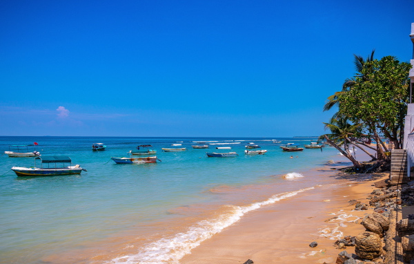 Лодки на берегу тропического пляжа на фоне голубого неба 