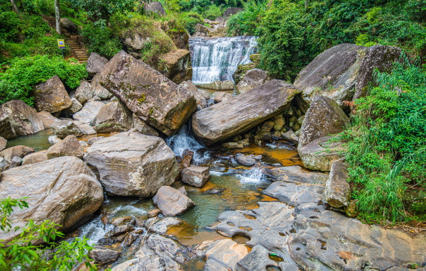 Лесной водопад стекает по огромным камням