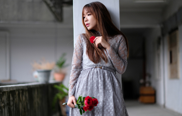 Девушка азиатка в сером платье с цветами розы
