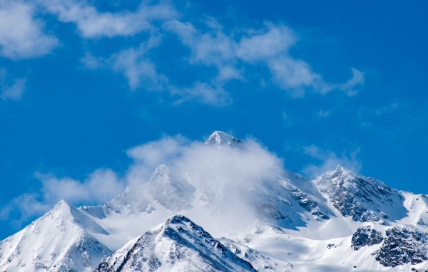 Голубое небо над покрытыми снегом горами