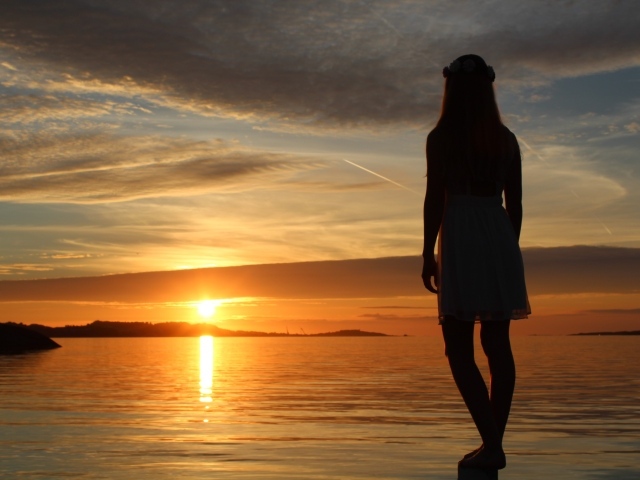 Девушка смотрит на закат в Норвегии