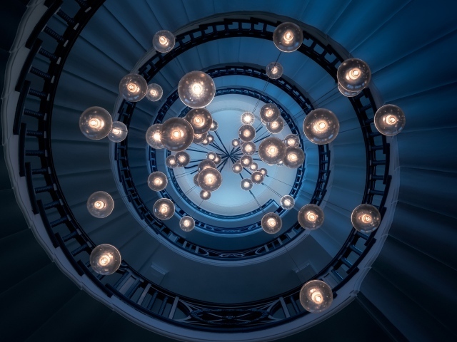 Большая люстра с висячими лампочками над лестницей
