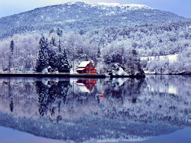 Дом, лес и гора отражают в озере зимой обои для рабочего