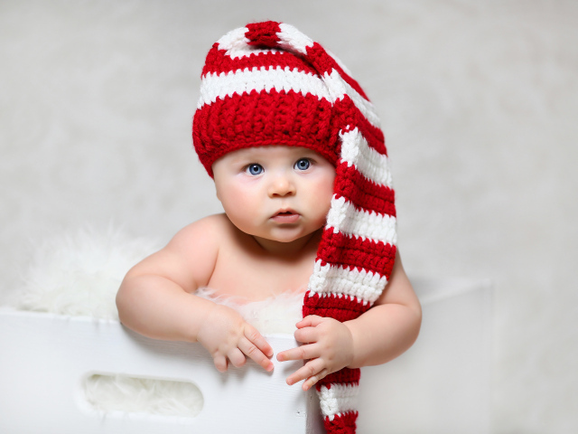 Blue-eyed baby in a long knitted hat