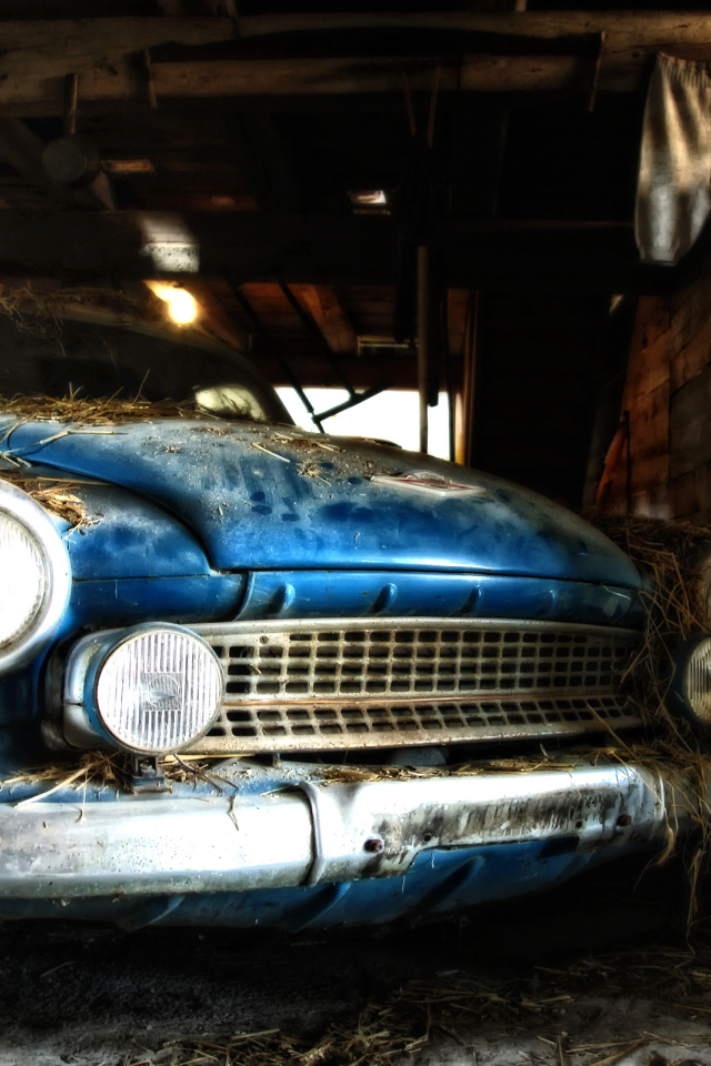 Старый автомобиль присыпан сеном в сарае