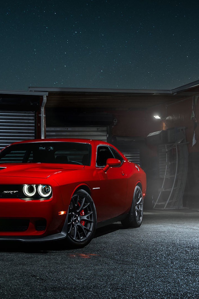 Красный Dodge Challenger Hellcat у гаража